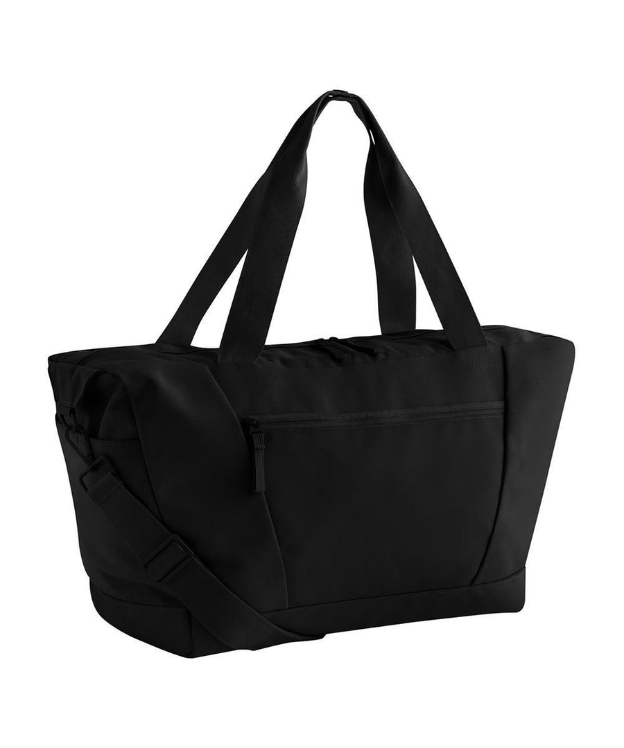 The Bags tote in black features two shoulder straps, a detachable crossbody strap, a front zip pocket, and a main zip fastening, displayed on a plain white background.