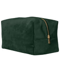 A rectangular dark green suede toiletry bag with a gold zip is displayed at an angle on a plain white background.
