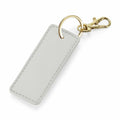 Introducing the Bagbase BG744, a rectangular gray keychain featuring a gold clasp and keyring. It boasts a textured surface with a neatly stitched border.