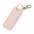 The BG744 by Bagbase is a rectangular pink keychain featuring a gold ring and a lobster clasp.