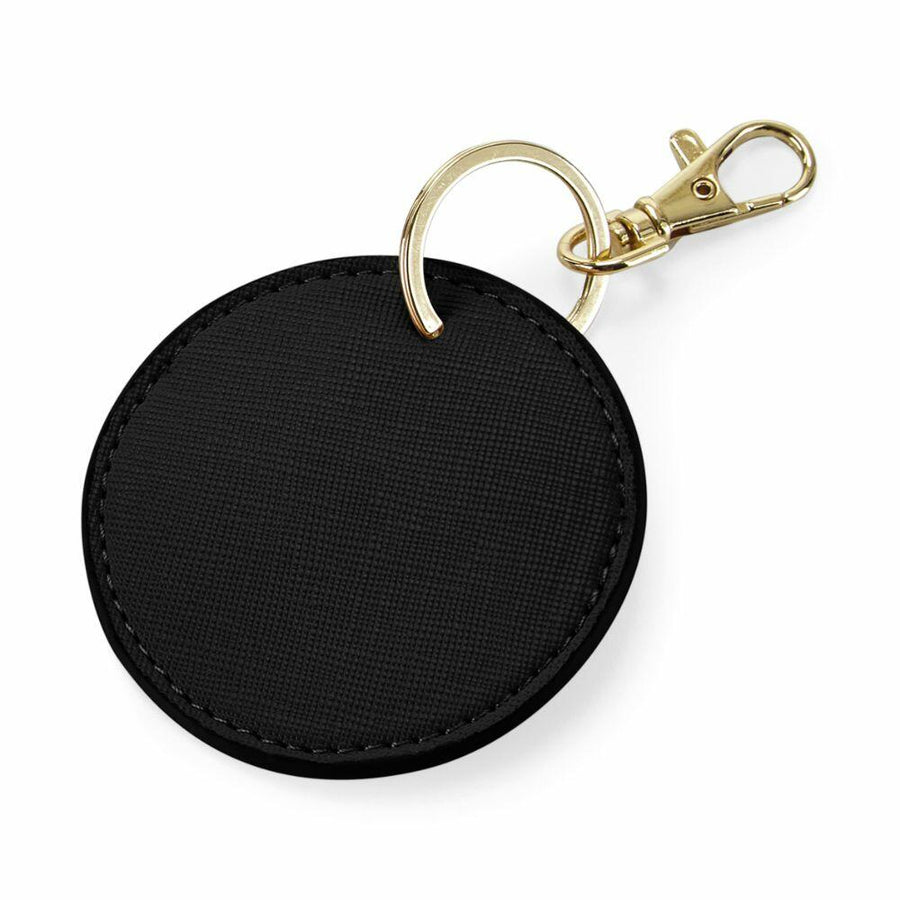 Bagbase BG745 keychain with a black circular design, featuring a gold ring and clasp.