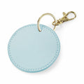 Introducing the Bagbase BG745: a round light blue keychain featuring a textured surface, complete with a gold-colored metal keyring and a convenient lobster clasp.