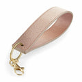 An accessory from Bagbase, the BG747 is a pink keychain wristlet with a textured design, featuring a gold metal clasp and keyring.