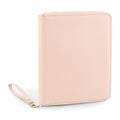 A leather portfolio from Bagbase, model BG756, is depicted closed against a white background. It showcases a light pink color with a textured surface, and features a wrist strap on the left side with a gold clasp for added elegance.
