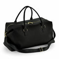 The Bagbase BG760 is a black leather duffel bag featuring gold zippers and a detachable shoulder strap.