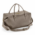 The Bagbase BG760 is a stylish, large gray duffel bag accented with gold zippers. It comes equipped with two handles and an adjustable shoulder strap for easy carrying.