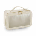 The Bagbase BG764 is a cream-colored toiletry bag for travel, featuring a transparent front panel, zipper closure, and a handle on top.
