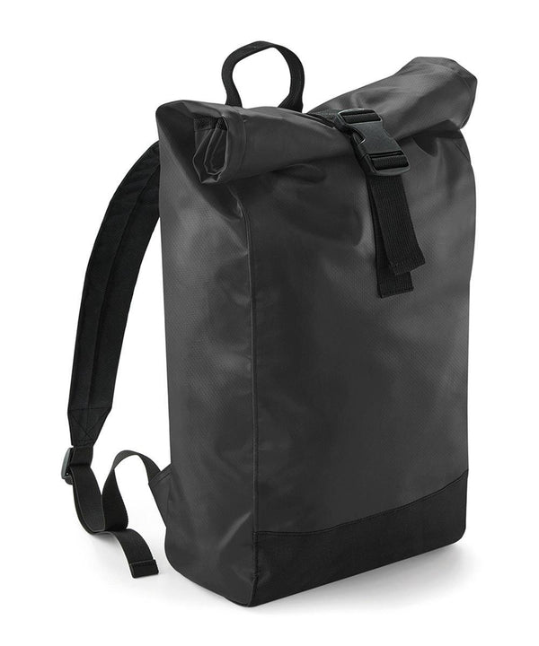 The Bagbase Tarp roll-top rucksack features a plain black design with adjustable shoulder straps, a top handle, and a black buckle fastening on the rolled flap, shown against a white background.