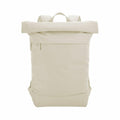 A Bagbase BG870 backpack in plain beige, featuring a roll-top design and a front zipper pocket, is displayed against a white background.