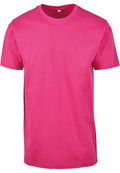 A plain pink T-shirt from Build Your Brand's BY004 collection is displayed against a white background. It features short sleeves and a classic crew neckline.