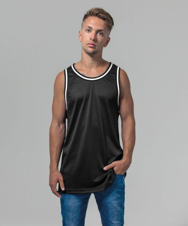 A man with short hair is standing with a neutral expression, wearing a sleeveless black shirt with white trim and blue jeans. The background is plain and light gray. He is wearing the BY009 by Build Your Brand.