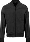 The BY045 jacket from Build Your Brand is a black bomber featuring a front zipper, a pocket on the sleeve, and ribbed detailing on the collar, cuffs, and hem.