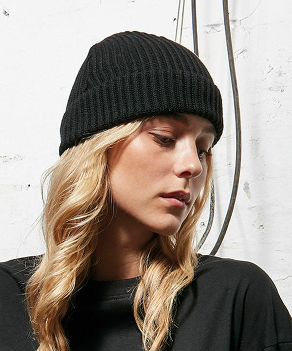 Person with long blonde hair wearing a black beanie and Build Your Brand BY154 black top, looking down.