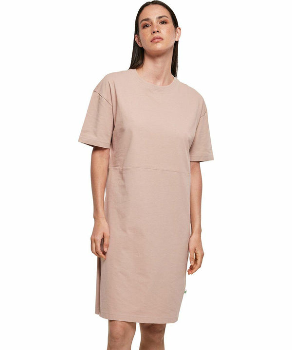 A person is posing in a plain, short-sleeved, knee-length, beige dress from Build Your Brand called the BY181.