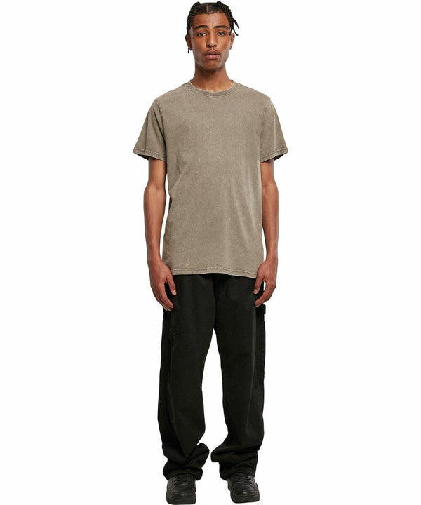 A person wearing a plain brown BY190 T-shirt by Build Your Brand, black cargo pants, and black shoes stands against a white background.