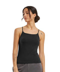A person with dark hair in a low bun wears the Build Your Brand Women's stretch jersey short slim top in black and grey trousers, standing against a white background with arms relaxed at their sides.