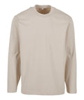 A beige, long-sleeve crew neck T-shirt is shown against a white background. The shirt features a plain design with no visible logos, patterns, or embellishments.