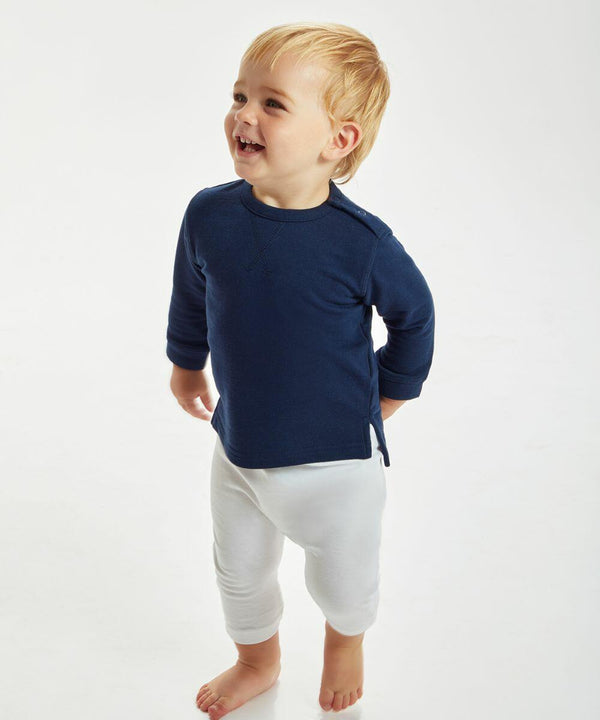 A young child stands smiling, wearing a Babybugz BZ031 in navy blue long-sleeve shirt and white pants against a plain white background.