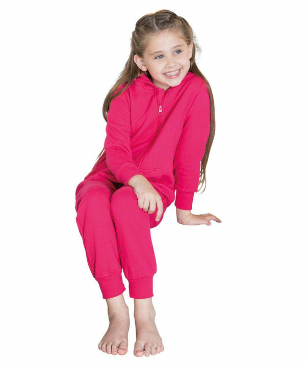 A young girl with long hair, wearing a red Comfy Co CC01J outfit, smiles while sitting with one foot on the ground and the other leg bent.