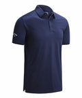 The Callaway CW025 is a navy blue polo shirt featuring a collar and short sleeves. It includes a three-button placket and displays the brand logo on the left sleeve. The fabric has a smooth, lightweight appearance.