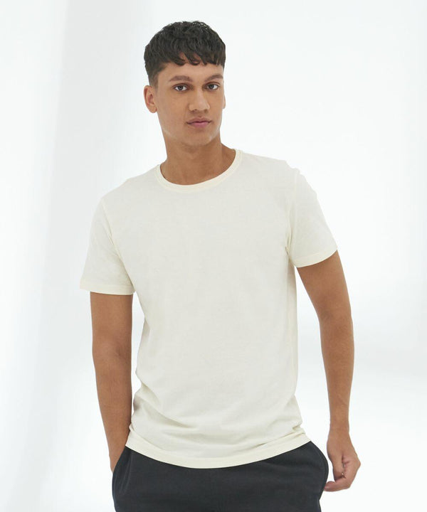 A person with short hair is wearing an AWDis Ecologie EA001 and black pants, standing against a white background.