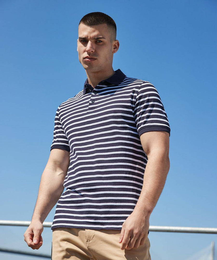 A man with a short haircut wears a navy and white striped Front Row FR230 polo shirt and beige pants, standing outdoors under a clear blue sky.