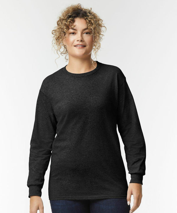 Person wearing a black GD014 long-sleeve shirt by Gildan and blue jeans, standing against a plain white background.