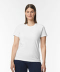 A person with long hair wearing a plain white GD026 t-shirt from Gildan and dark pants stands against a solid white background.