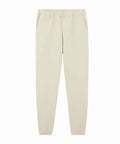 A pair of light beige joggers featuring an elasticated waistband, side pockets, and elasticated cuffs, shown against a plain white background.