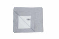 A neatly folded GD101 gray blanket by Gildan, with a label visible on the inner corner, showcases well-defined edges and a soft texture, displayed against a plain white background.