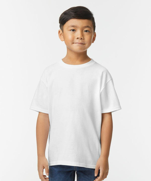 A young boy stands facing the camera, wearing a Gildan GD24B plain white T-shirt and blue jeans against a plain white background.