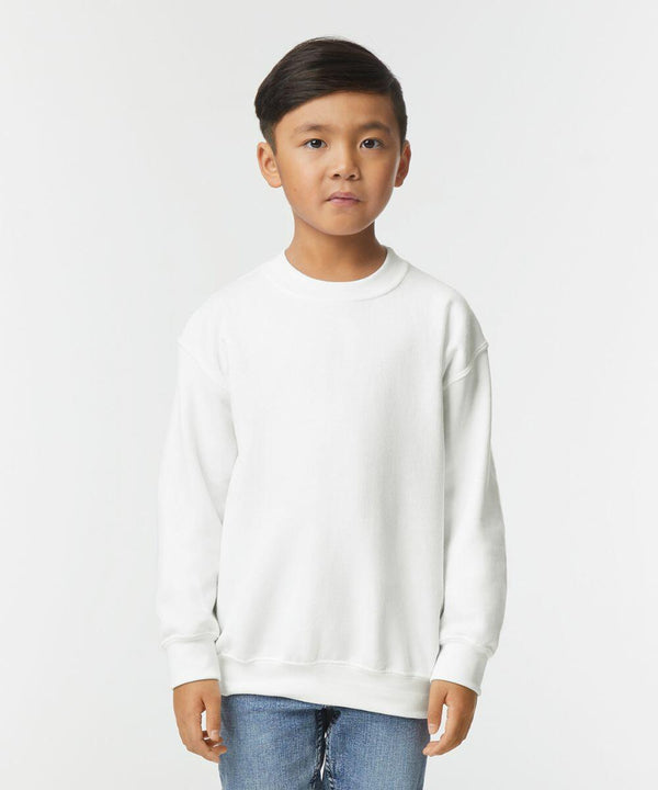 A young boy is standing and wearing a Gildan GD56B sweatshirt and blue jeans against a plain white background.