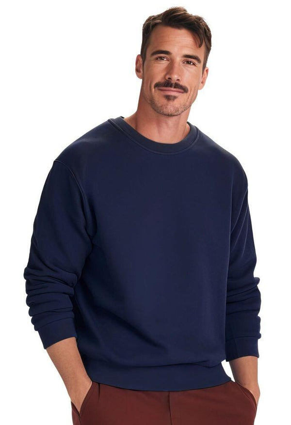 A man with short dark hair and a mustache is wearing a Uneek Adult Eco sweatshirt and brown pants, standing against a plain white background.