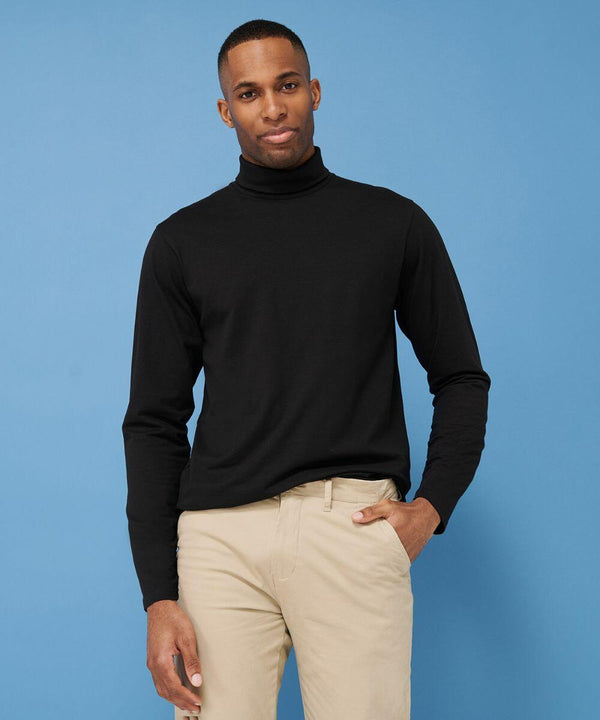 A man wearing a black Henbury HB020 turtleneck and beige pants poses against a blue background.