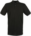 The Henbury HB101 is a plain black polo shirt with short sleeves and a collar, featuring a three-button placket.