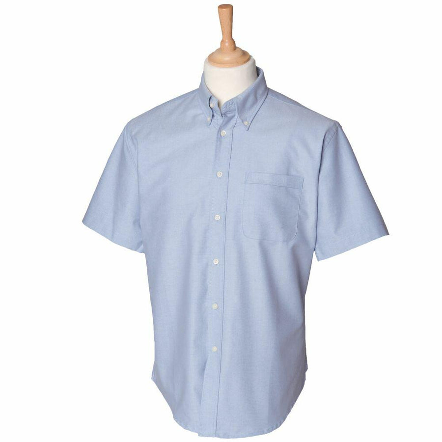 HB515 by Henbury displayed on a mannequin torso with a wooden neck stand, featuring a light blue short-sleeve button-up design.