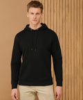 A man wearing a black Henbury HB841 hoodie and beige pants stands in front of a wooden panel background.