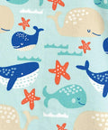 Experience the playful ocean scene of Home & Living's HL007 product, featuring a light turquoise background adorned with blue, teal, and beige whales of varying sizes and expressions swimming amid orange starfish and subtle waves.