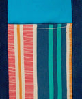 Close-up of the HL204 fabric by Home & Living, featuring vertical stripes in red, orange, cream, teal, and navy blue next to a solid blue section.