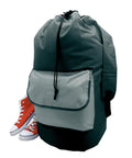 A large grey Bags duffel with a front pocket and drawstring fastening stands upright, accompanied by red high-top trainers with white laces and soles placed beside it.