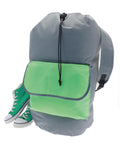 A grey Bags rucksack with a light green pocket and black drawstring is placed beside green high-top trainers with white soles and laces, all set against a white background.