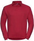 The Russell J012M is a red long-sleeve polo shirt featuring a collar and button-up neckline, displayed against a white background. It boasts simple stitching and offers a relaxed fit.