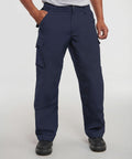 Man wearing navy blue cargo pants, a grey t-shirt, and Russell J015M black shoes, with hands in pockets.