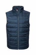 Product J441M by Russell is a dark blue quilted puffer vest featuring a sleeveless design, front zipper, and two side pockets, set against a plain white background.