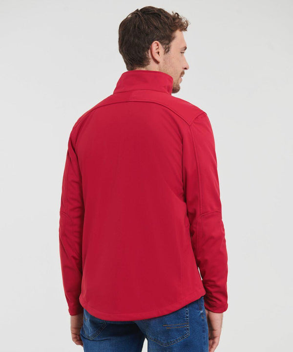 A man wearing a Russell J520M red jacket and blue jeans is turned away from the camera, with his back and side profile visible against a plain white background.