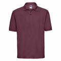 The Russell J539M is a maroon short-sleeve polo shirt featuring a classic collar and three-button placket, showcased against a plain white background.