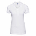 The Russell J566F is a plain white women's polo shirt, showcased against a white background. This shirt features short sleeves and a collar with a buttoned placket.