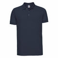 The Russell J566M is a navy blue polo shirt featuring a classic collar and three buttons. It has short sleeves and boasts a simple, solid design.