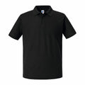 A J570M polo shirt from Russell, in a plain black design featuring a collar and short sleeves, set against a white background.