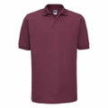 A maroon J599M polo shirt by Russell with short sleeves and a collar is displayed against a white background. The shirt features a simple, classic design with no visible logos or embellishments.